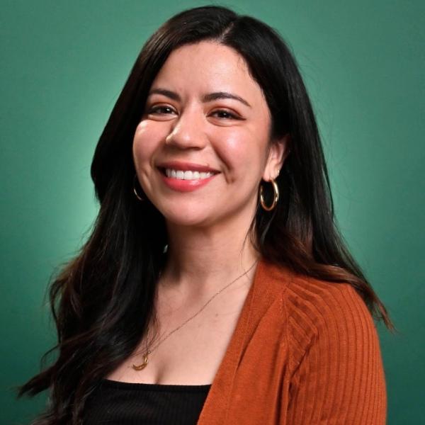 a headshot of a woman in front of a green background